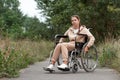 A young disabled girl sits in a wheelchair on the street. The concept of a wheelchair, disabled person, full life, paralyzed, Royalty Free Stock Photo