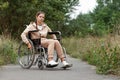 A young disabled girl sits in a wheelchair on the street. The concept of a wheelchair, disabled person, full life, paralyzed,