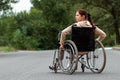 A young disabled girl sits in a wheelchair on the street. The concept of a wheelchair, disabled person, full life, paralyzed, Royalty Free Stock Photo