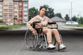 A young disabled girl sits in a wheelchair on the street. The concept of a wheelchair, disabled person, full life, paralyzed,