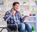 Young disabled injured man opening the fridge door Royalty Free Stock Photo