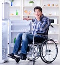 Young disabled injured man opening the fridge door Royalty Free Stock Photo