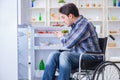 The young disabled injured man opening the fridge door Royalty Free Stock Photo