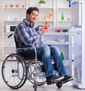 Young disabled injured man opening the fridge door Royalty Free Stock Photo