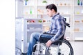 The young disabled injured man opening the fridge door Royalty Free Stock Photo