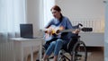 A young disabled lady is teaching how playing the guitar Royalty Free Stock Photo