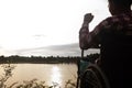 Young disabled man with blue sky background.He is alone and sitting on wheelchair.He is looking into river Royalty Free Stock Photo