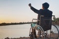 Young disabled man with river background.He is sitting on wheelchair and looking into river Royalty Free Stock Photo