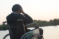 Young disabled man with river background.He is sitting on wheelchair Royalty Free Stock Photo