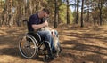 A young disabled man in a wheelchair and a dog in the park