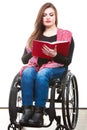 Young disabled woman in wheelchair with book. Royalty Free Stock Photo