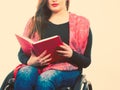 Young disabled woman in wheelchair with book. Royalty Free Stock Photo