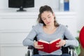 Young disabled woman on wheelchair reading book Royalty Free Stock Photo