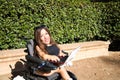 young disabled woman in wheelchair and reduced mobility with her laptop computer teleworking in the park Royalty Free Stock Photo