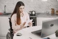 Young disabled woman in wheelchair working with laptop and tablet at home Royalty Free Stock Photo