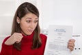 Young disappointed woman staring at business contract in german