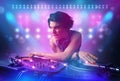 Disc jockey mixing music on turntables on stage with lights and stroboscopes Royalty Free Stock Photo