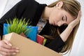 Young dismissed female worker in office holding carton box with Royalty Free Stock Photo