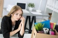 Young dismissed female worker in office sitting near carton box Royalty Free Stock Photo