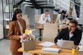 Young dismissed woman packing stuff into box at office Royalty Free Stock Photo