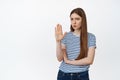 Young displeased woman shaking hand palm negative gesture, rejecting smth bad, refusing offer, say no stop, standing Royalty Free Stock Photo