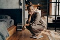 Young dissatisfied unhappy woman crouched over electronic scales