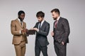 Young diverse business men stand looking at purse discussing money