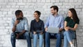 Young diverse candidates laughing, chatting, waiting for job interview Royalty Free Stock Photo