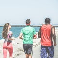 Young diverse culture joggers running next to the sea harbor - Runners training outdoor - Sport and healthy lifestyle concept -