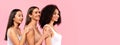 Young diverse ladies models looking aside at free space, posing on pink studio background, panorama, banner Royalty Free Stock Photo