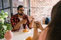 Young diverse loving couple eating croissant and talks together at home in breakfast time. Communication and