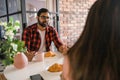 Young diverse loving couple eating croissant and talks together at home in breakfast time. Communication and