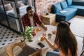 Young diverse loving couple eating croissant and talks together at home in breakfast time. Communication and