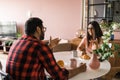 Young diverse loving couple eating croissant and talks together at home in breakfast time. Communication and