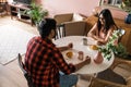 Young diverse loving couple eating croissant and talks together at home in breakfast time. Communication and