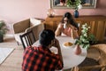 Young diverse loving couple eating croissant and talks together at home in breakfast time. Communication and