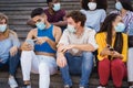 Young diverse people using mobile phones wearing safety mask outdoor in the city - Focus on gay man face Royalty Free Stock Photo