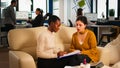 Young diverse woman holding paper document discussing about contract