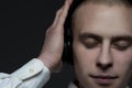 Young DJ guy listening to music in headphones