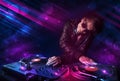 Young DJ playing on turntables with color light effects Royalty Free Stock Photo