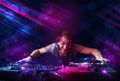 Young DJ playing on turntables with color light effects Royalty Free Stock Photo