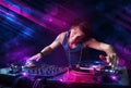 Young DJ playing on turntables with color light effects Royalty Free Stock Photo