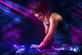 Young DJ playing on turntables with color light effects Royalty Free Stock Photo