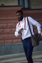 Young doctor of African nationality walking outdoors with stethoscope on his neck