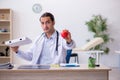 Young male doctor dietician holding apple and pizza box