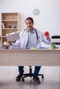 Young male doctor dietician holding apple and pizza box
