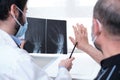 Young doctor examining x-ray of hands of a senior patient with arthritis Royalty Free Stock Photo