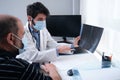 Young doctor examining x-ray of hands of a senior patient with arthritis Royalty Free Stock Photo