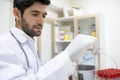 Young doctor holding empty blood sample and check the label before give to patient in the clinic or hospital. Looking at plastic Royalty Free Stock Photo