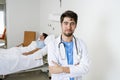 Young doctor at hospital bedroom with sick patient lying in bed Royalty Free Stock Photo